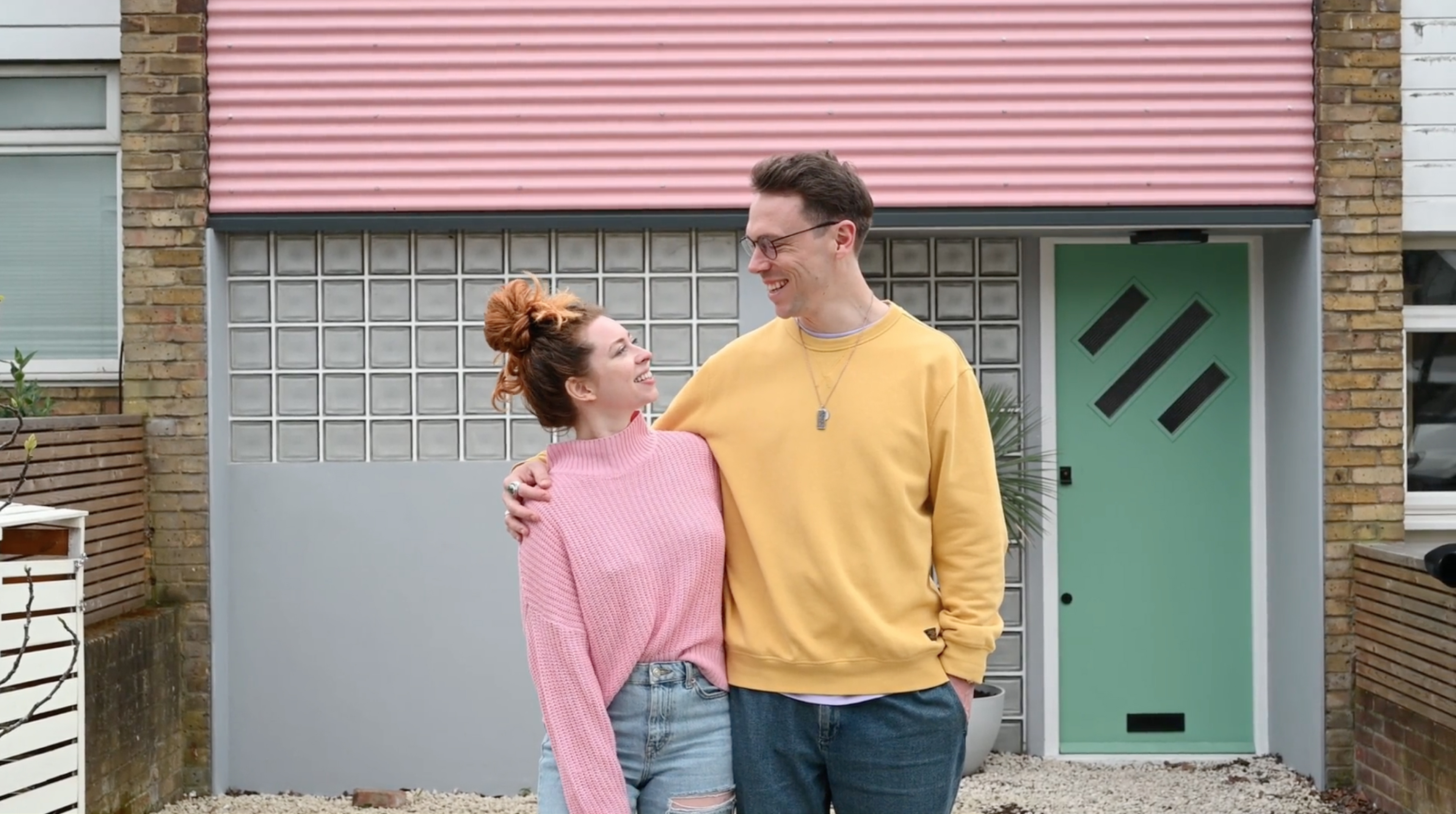 Man and woman in front of a home