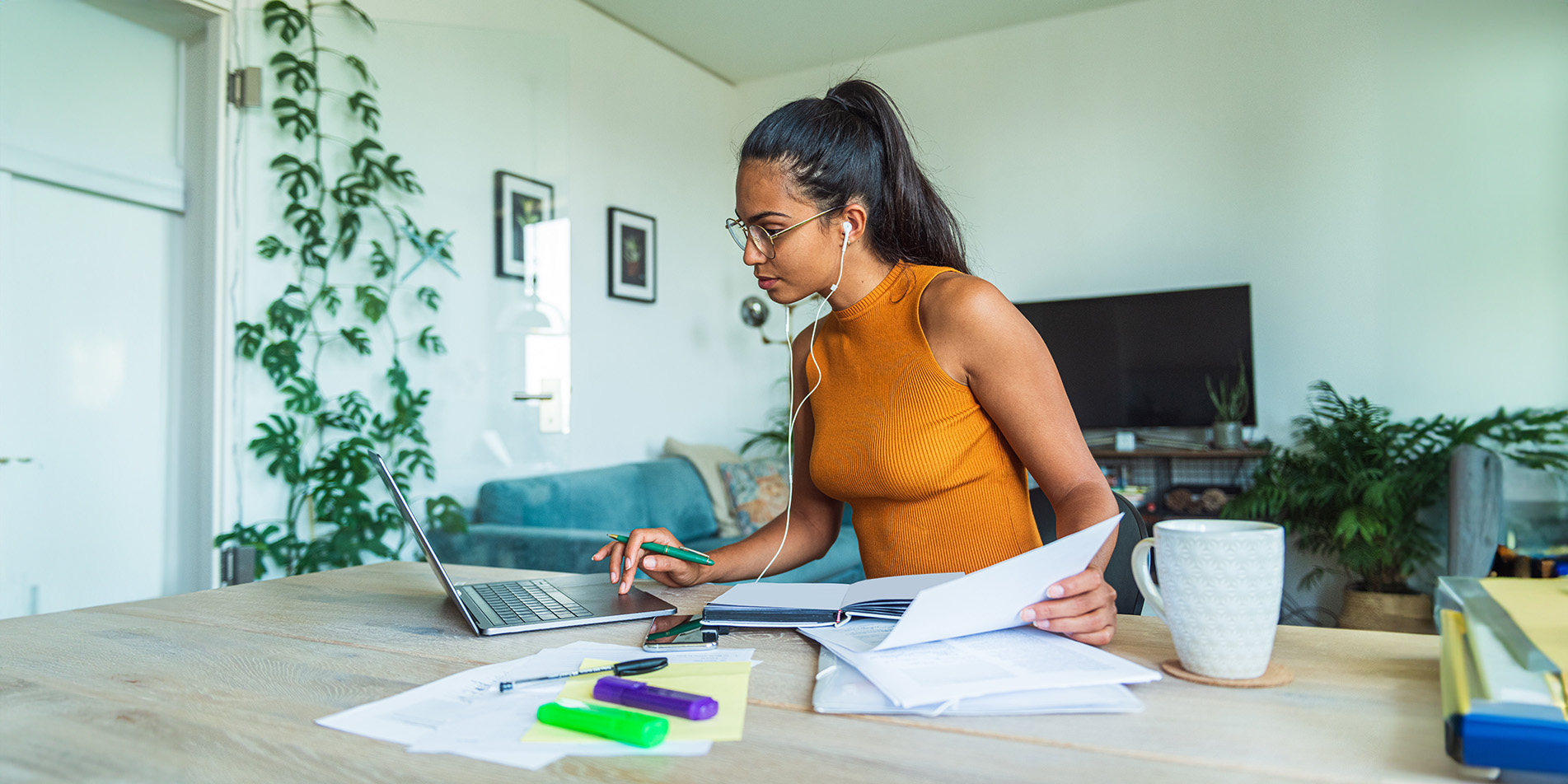 woman-looking-at-laptop-with-paperworks-in-hand